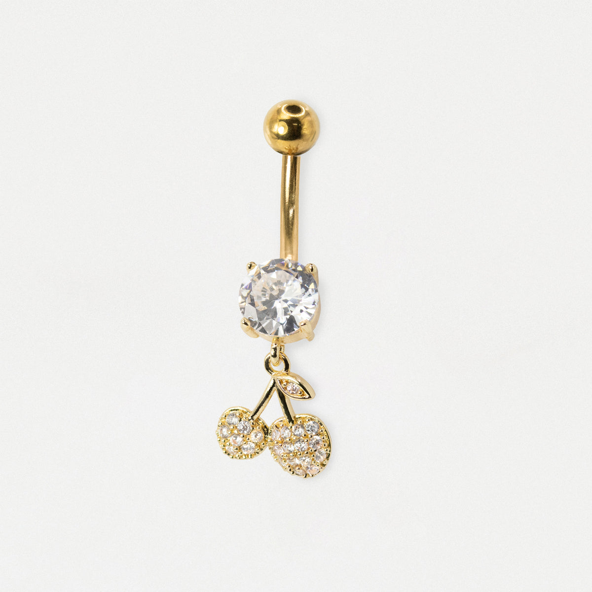 A Gold Steel belly bar featuring a claw-set round clear crystal solitaire and a dangling pavé-set Christmas star charm with clear crystals by Kingsley Ryan Wholesale on a pale grey background.