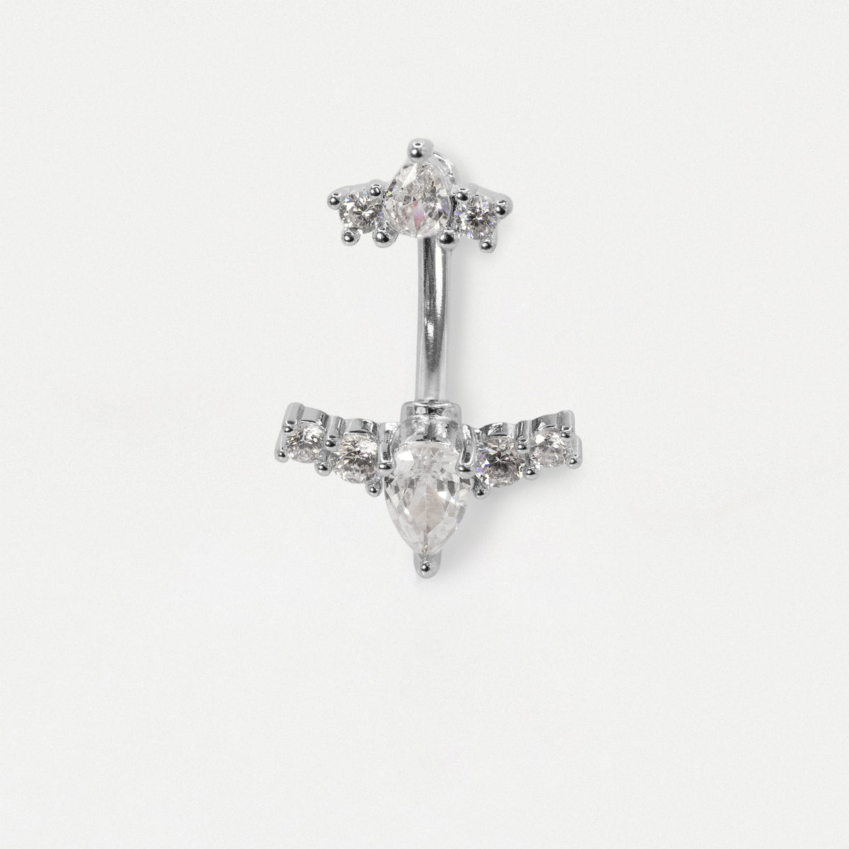 A silver-toned belly button ring featuring a central teardrop-shaped clear gemstone and smaller clear stones arranged in a decorative top and side settings, shown on a plain light background.