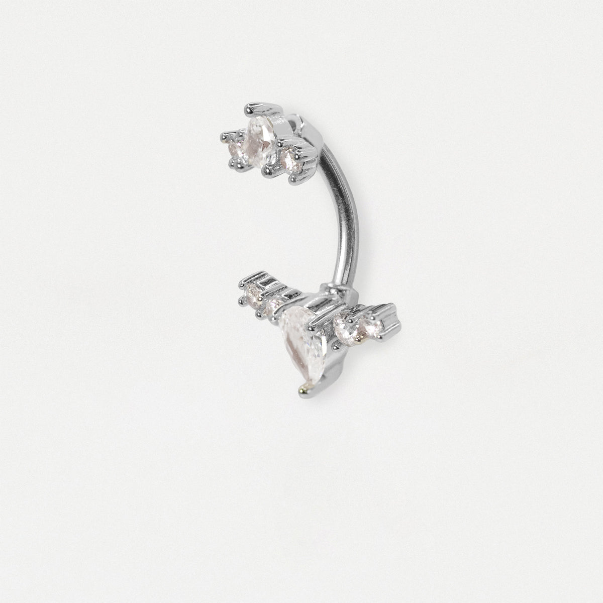 A steel curved barbell belly button piercing adorned with clear faceted gemstones, shown on a plain light gray background.