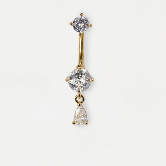 A gold-plated vertical barbell belly button ring with three clear gemstones of varying sizes, set against a plain white background.