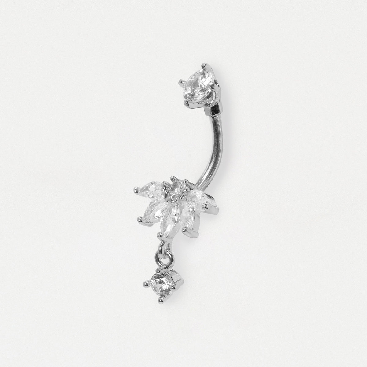 A silver-toned curved barbell belly button ring decorated with dangling clear crystal flowers and a small crystal drop, shown on a plain light gray background.