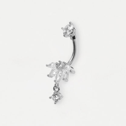 A silver-toned curved barbell belly button ring decorated with dangling clear crystal flowers and a small crystal drop, shown on a plain light gray background.