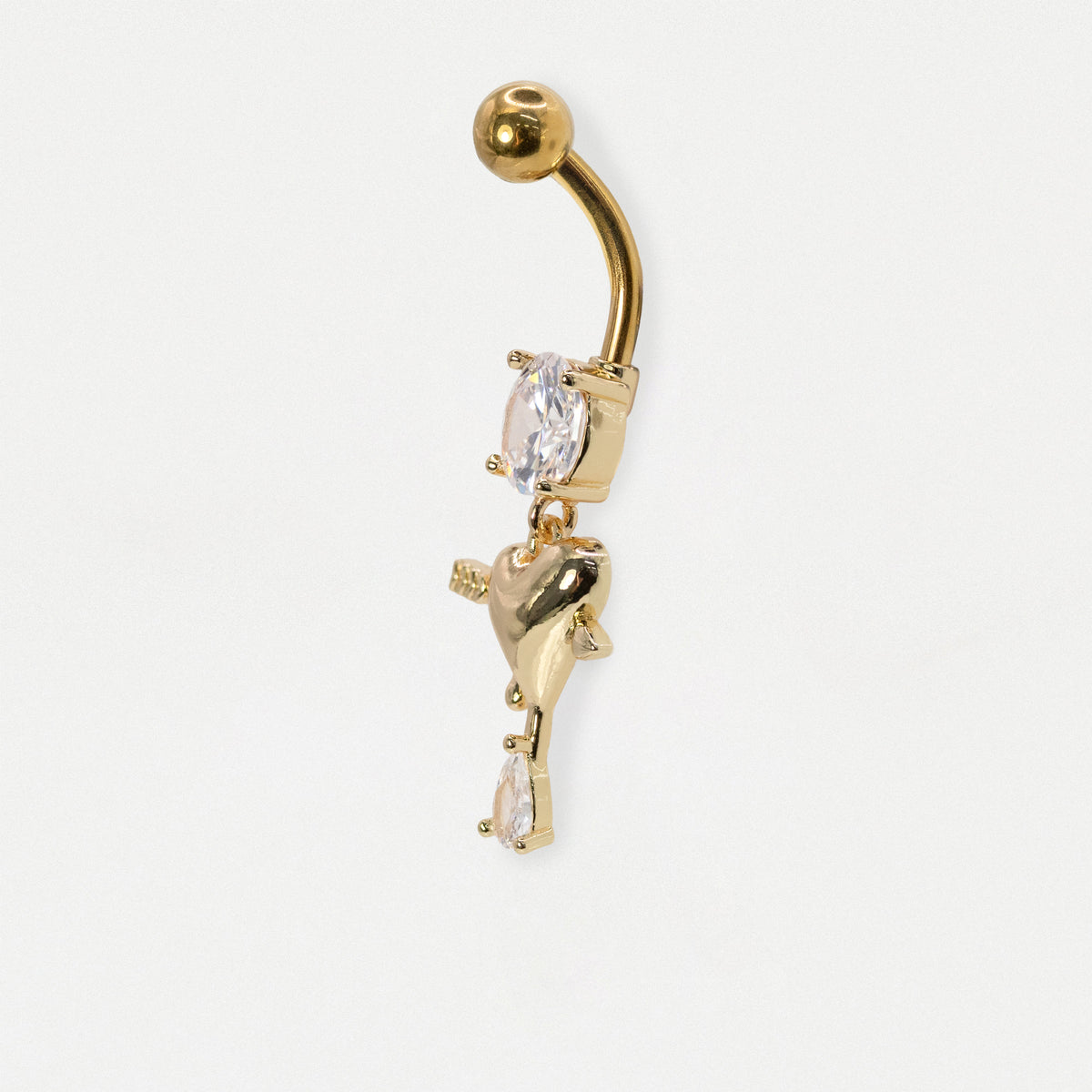 A side profile of a gold pvd steel navel bar with a clear crystal gemstone and a dangling heart design on a white background.