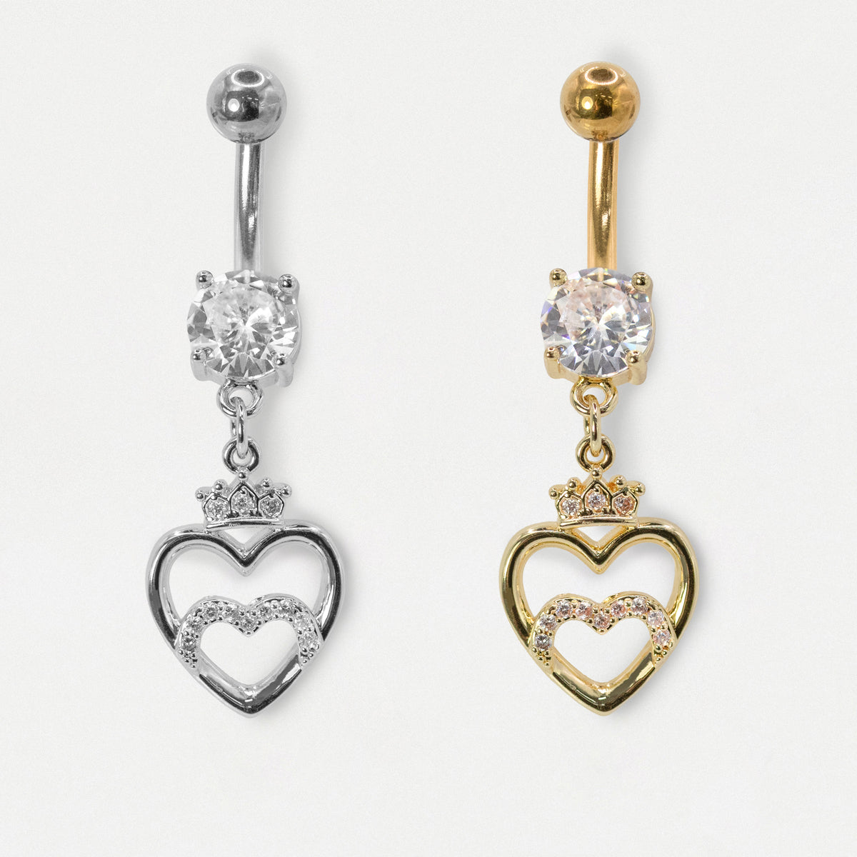An image on a white background of a 316L Grade Steel and a Gold PVD Steel belly bar featuring a round clear crystal solitaire and an open heart dangle charm topped with a mini crown and clear crystal pavé by Kingsley Ryan Wholesale