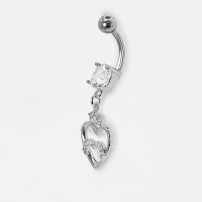 A steel navel bar on its side showing the curved bar set with a clear crystal and a dangling open heart design with a small crown
