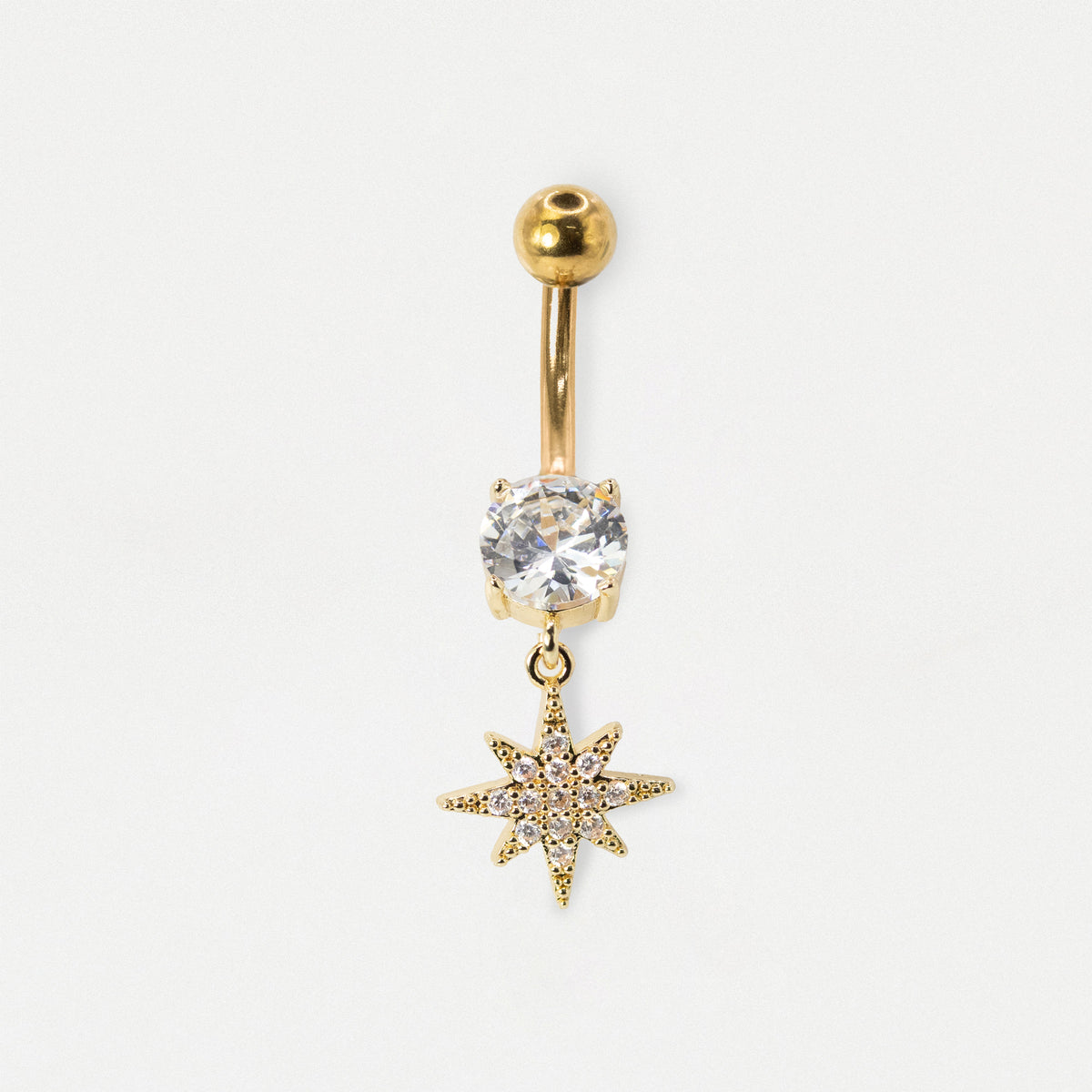 A gold-plated belly button ring featuring a round clear crystal and a dangling gold star charm, set against a plain white background.