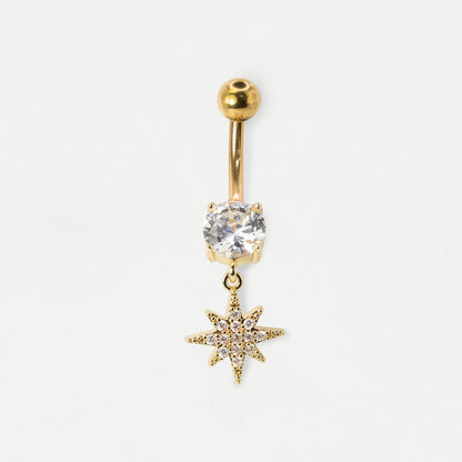 A gold-plated belly button ring featuring a round clear crystal and a dangling gold star charm, set against a plain white background.