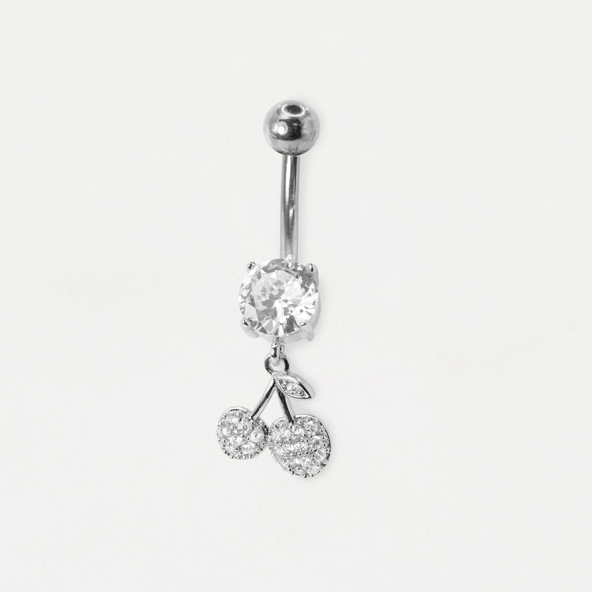 A steel belly button ring featuring a single round clear crystal and a dangling double-cherry charm set with small clear crystals, shown on a plain light gray background.