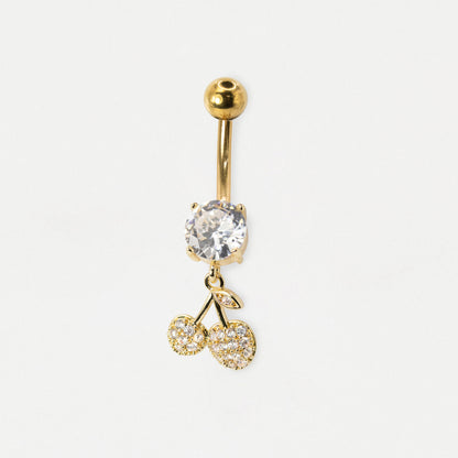 A Gold Steel belly bar featuring a claw-set round clear crystal solitaire and a dangling pavé-set Christmas star charm with clear crystals by Kingsley Ryan Wholesale on a pale grey background.