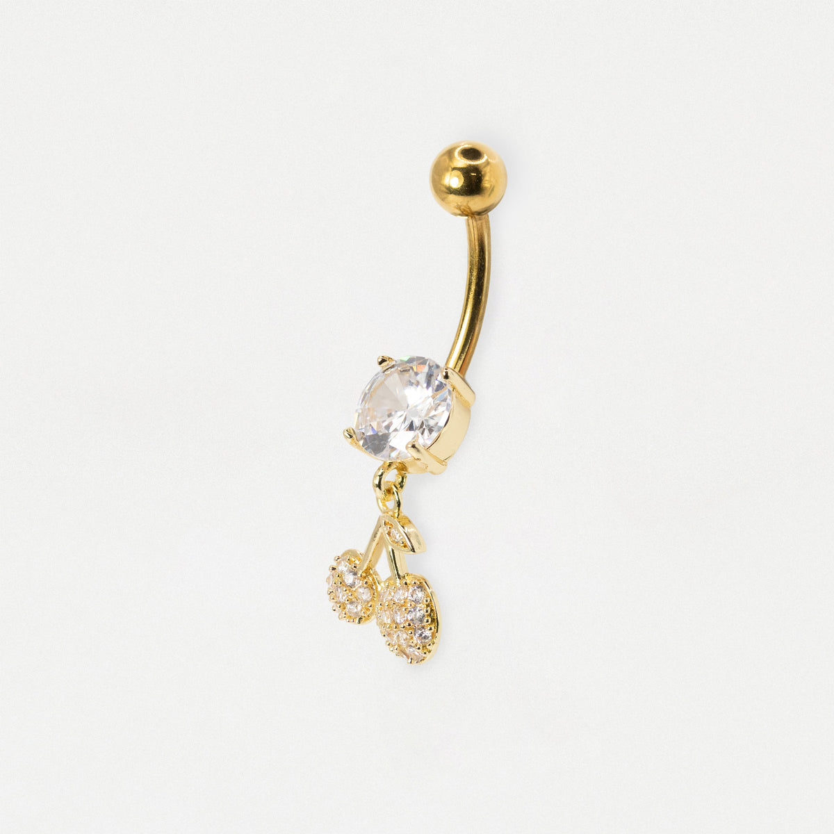 Gold curved barbell belly button ring with a clear faceted gemstone and two dangling cherry charms, shown on a plain white background.