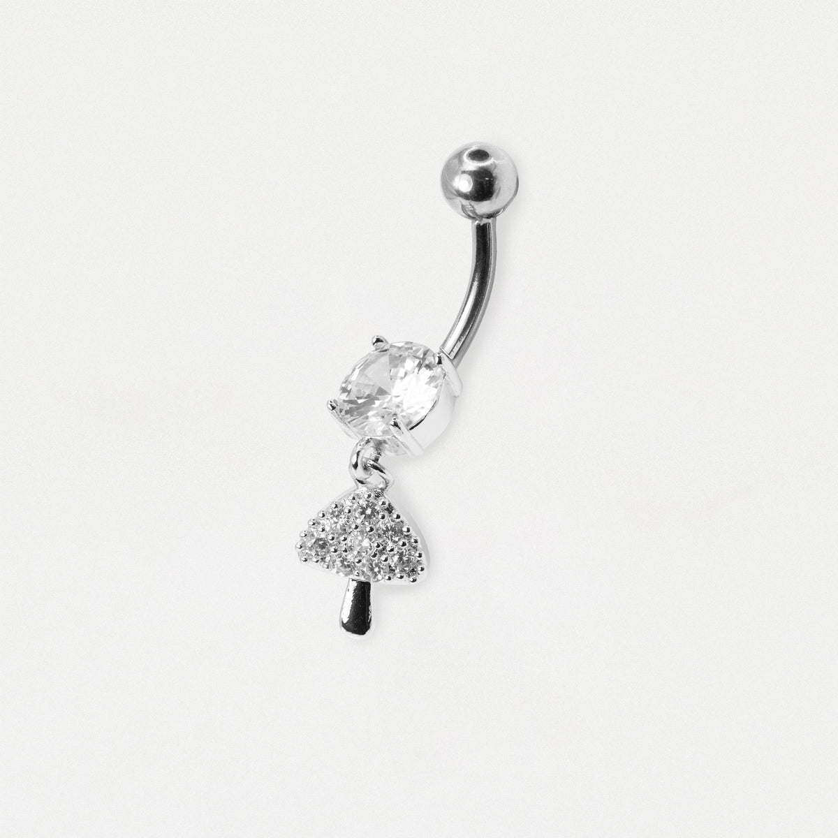A silver-toned curved barbell belly button ring featuring a clear faceted gemstone and a dangling tree charm, shown on a plain light gray background.
