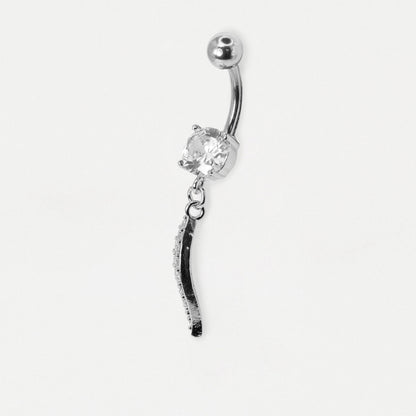 A silver-toned belly button ring featuring a curved barbell, a clear faceted gemstone, and a dangling black-and-silver textured charm, shown on a plain light gray background.