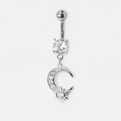 A silver-toned belly button ring featuring a ball top, a clear rhinestone-set oval charm, and a dangling crescent moon and sun charm embellished with small clear stones, shown on a plain light background.