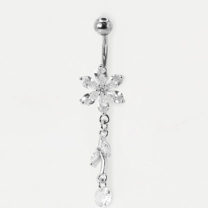 A Steel belly bar with a flower design set with claw-set clear crystals and a two-marquise leaf dangle by Kingsley Ryan Wholesale on a pale grey background.