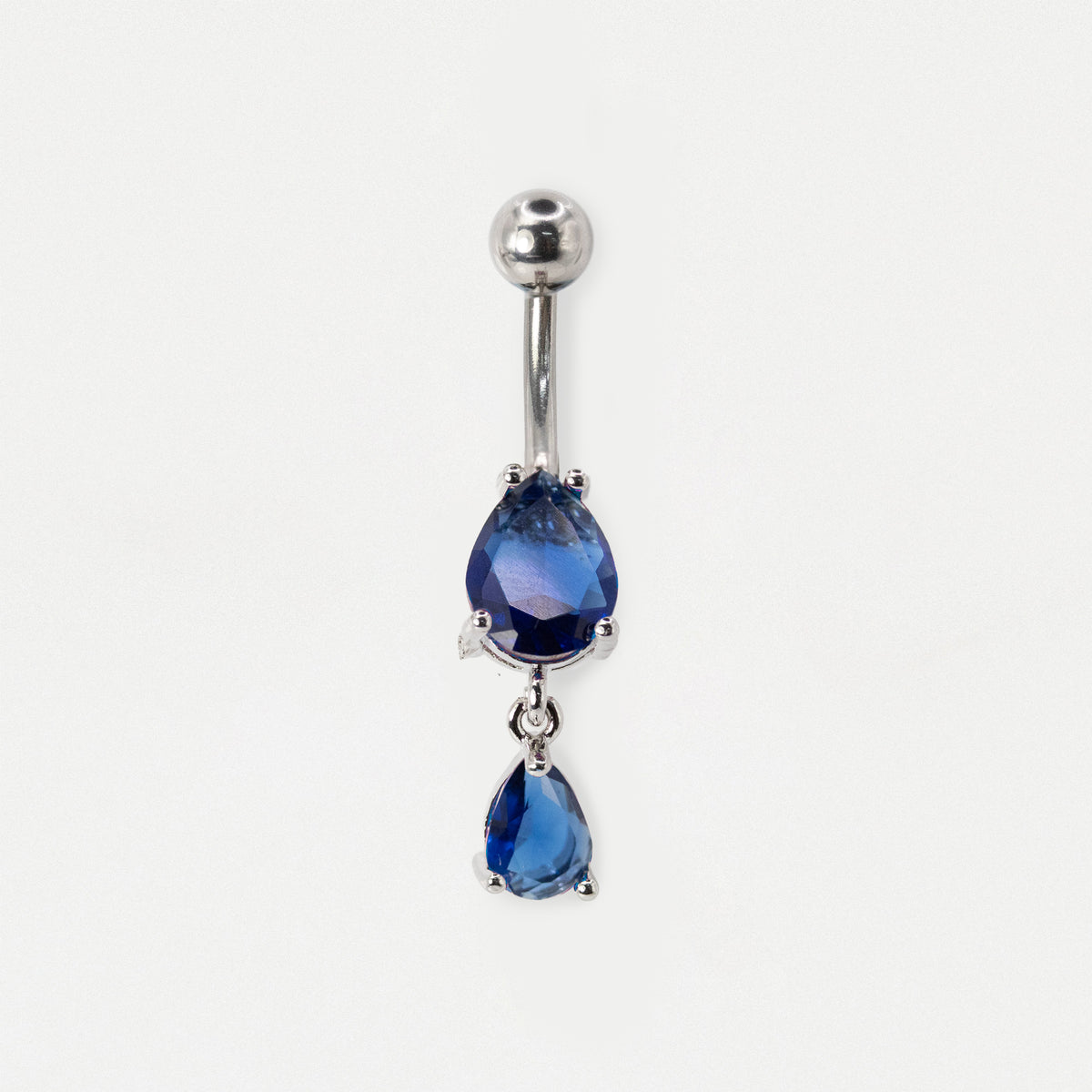 A steel belly button ring featuring two dangling teardrop-shaped sapphire gemstones on a plain white background.