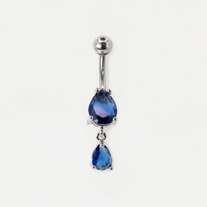 A steel belly button ring featuring two dangling teardrop-shaped sapphire gemstones on a plain white background.